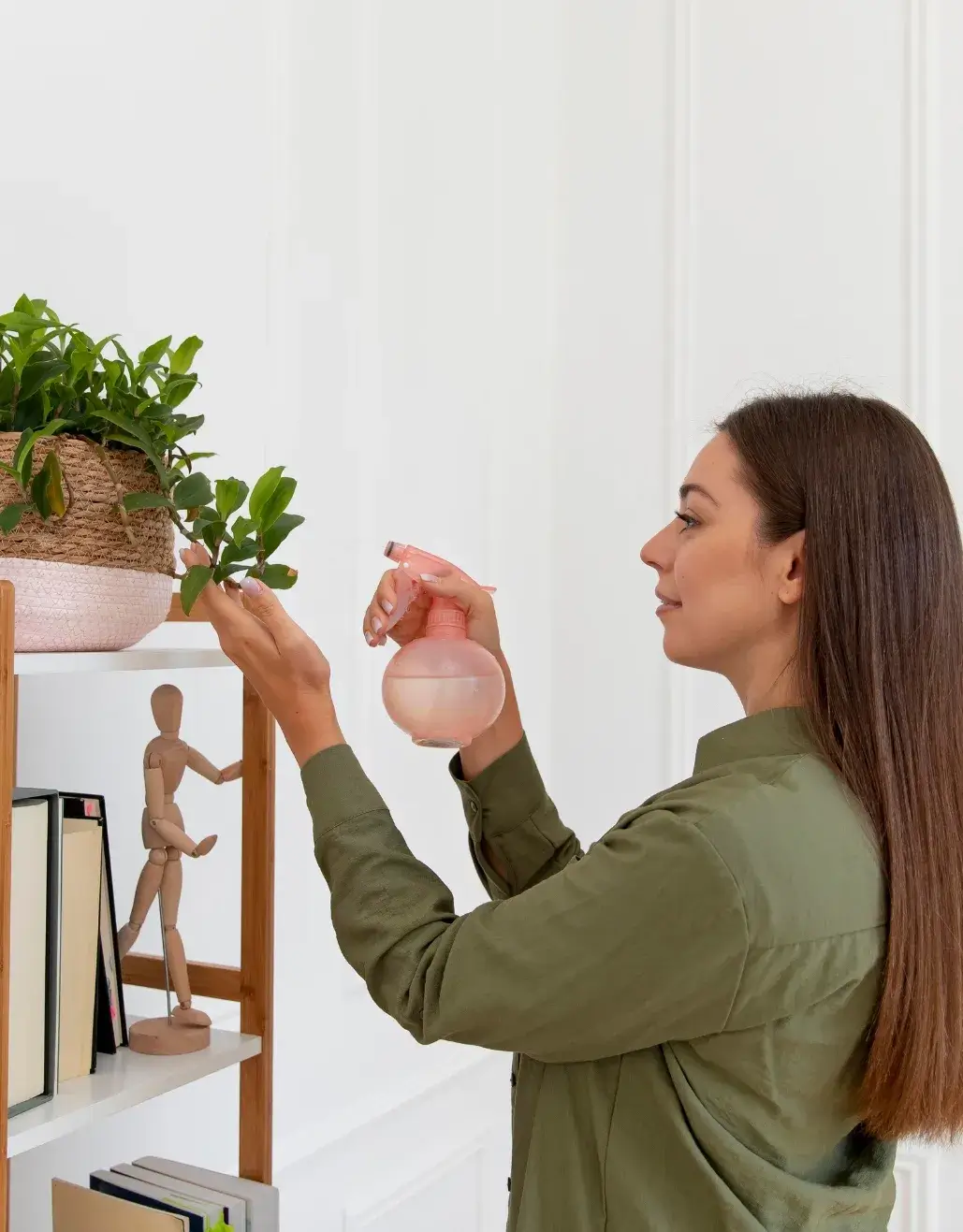 Woman spraying water on a houseplant during spring cleaning in a modern home.
